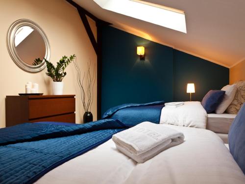 a bedroom with two beds and a mirror at Blooms Inn & Apartments in Poznań