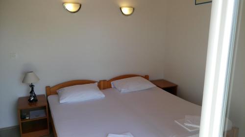 a bedroom with a white bed with two white pillows at Guesthouse Budima in Banići