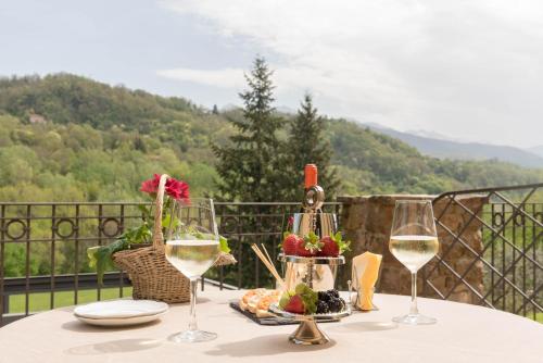 a table topped with a glass of wine and flowers at Cà Del Moro Resort in Pontremoli