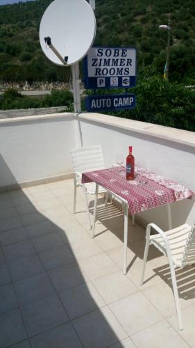 a table and two chairs with a bottle of wine on it at Guesthouse Budima in Banići