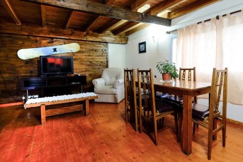 sala de estar con mesa y tabla de surf en la pared en Cabañas Don Pepe en San Carlos de Bariloche