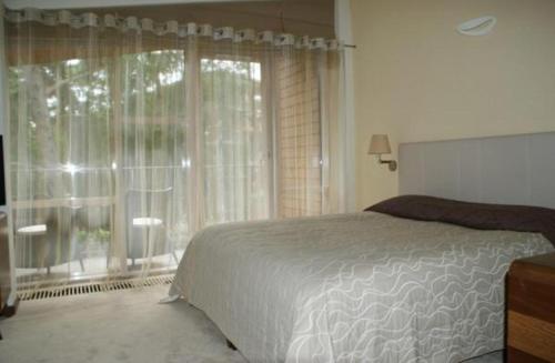 a bedroom with a bed and a large window at Guest House Aštuoni in Palanga