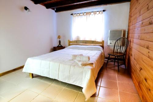 a bedroom with a white bed and a window at Cabañas Don Pepe in San Carlos de Bariloche