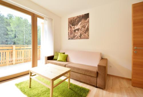 a living room with a couch and a large window at Apartmenthaus Fuchsmaurer in Bressanone