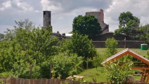 a view of a castle from a garden with trees at Vár-Liget Vendégház in Kisnána