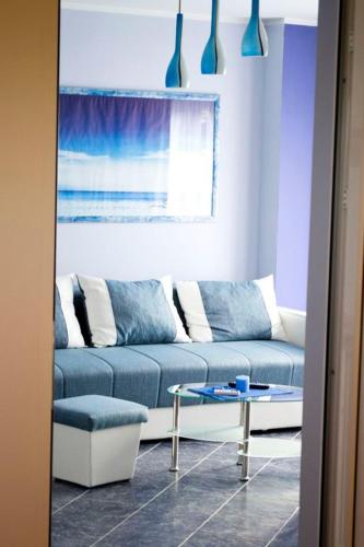 a living room with a blue couch and a table at Vila El Barco in Veliko Gradište