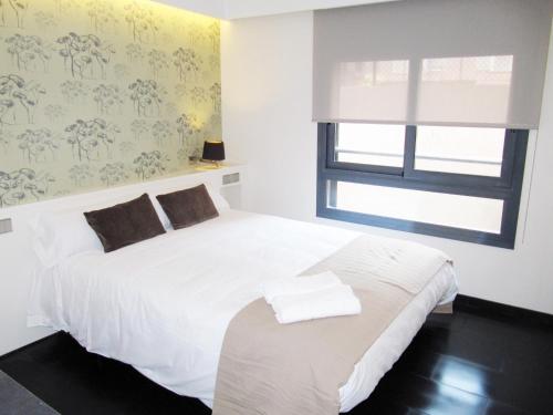 a bedroom with a white bed and a window at Barcelona Fifteen central Aparthotel in Barcelona