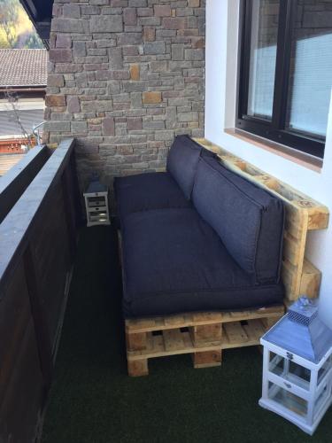 a couch sitting on a porch next to a brick wall at Landhaus Osttirol in Iselsberg