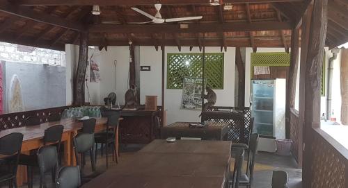 a dining room with a wooden table and chairs at Sandy Beach Hotel in Arugam Bay