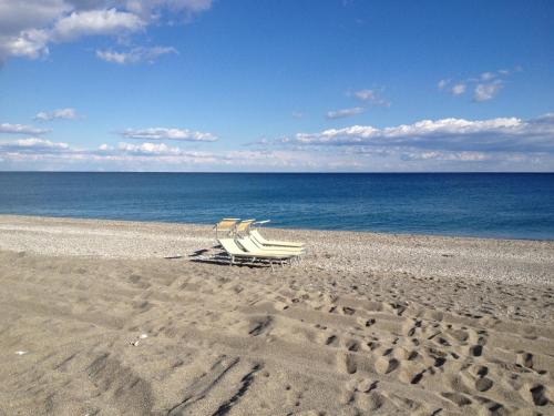 a couple of chairs sitting on a beach at La Casa del Miele di Borgo Carbone in Locri