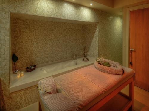 a bathroom with a bath tub and a table with a mirror at Lvzz Hotel in Bodrum City