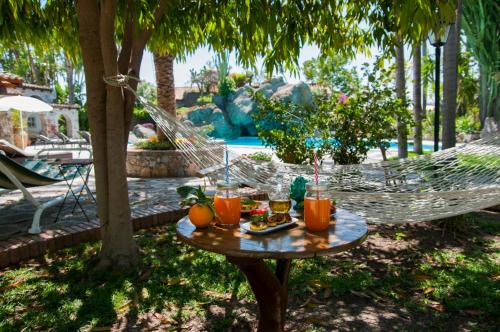 a table with drinks on it next to a hammock at B&B La Villa in Giardini Naxos