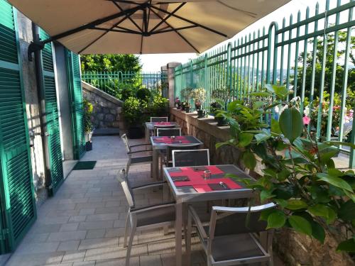 a patio with tables and chairs and an umbrella at B&B Via delle 5 Terre in La Spezia