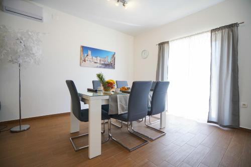 una sala da pranzo con tavolo e sedie blu di TJ Apartment 2 Zadar a Zara (Zadar)