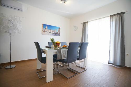 a dining room with a table and blue chairs at TJ Apartment 2 Zadar in Zadar