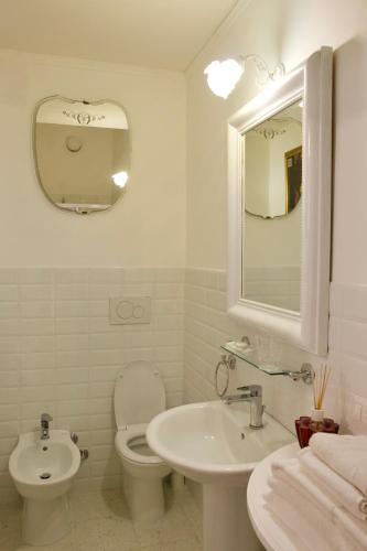 a bathroom with a toilet and a sink and a mirror at B&B Lido Liberty in Lido di Ostia