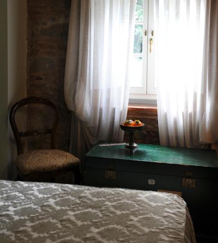 a bedroom with a bed and a chair and a window at Relais Del Lago in Capannori