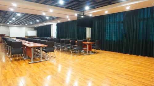 a conference room with chairs and tables and a stage at Nostalgia Hotel Tianjin Binhai Tanggu 时光漫步酒店天津滨海塘沽站店 Free fresh ground coffee,Free laundry service in Tianjin