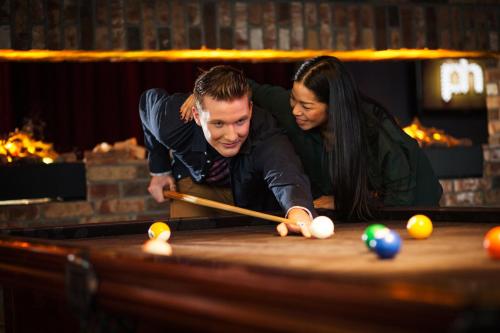 a man and a woman playing a game of pool at pentahotel Reading in Reading