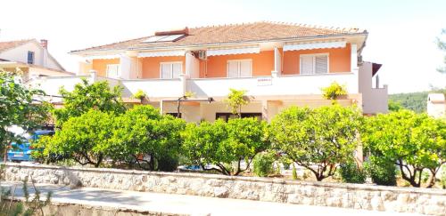 a large house with trees in front of it at Apartments and Rooms Dobrila in Jelsa