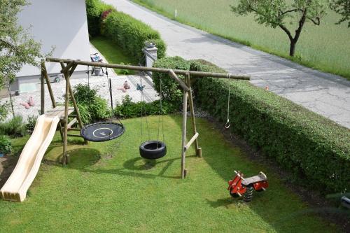 an outdoor playground with swings and a slide at Appartement Stichauner in Tschöran
