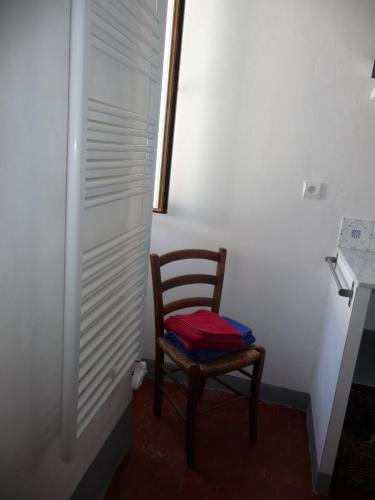 une chaise en bois assise dans une pièce avec fenêtre dans l'établissement Casa A Rota Chambres d'Hôtes, à Ersa