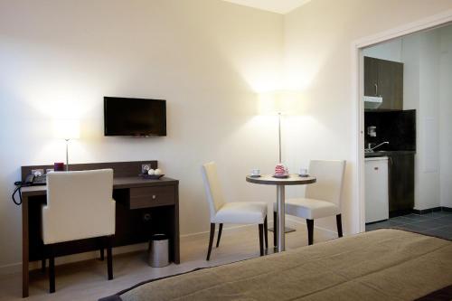 a room with a desk and a table and chairs at Residhome Reims Centre in Reims