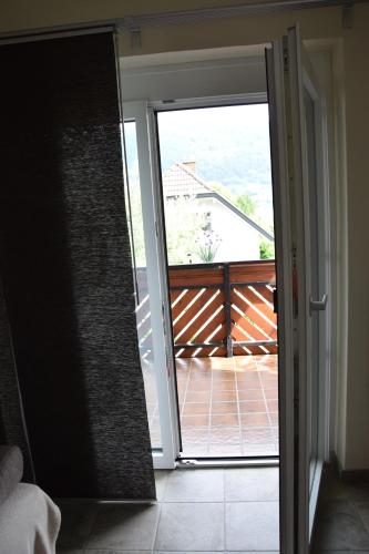 an open sliding glass door with a view of a balcony at Appartement Stichauner in Tschöran