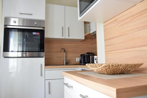 a kitchen with white cabinets and a bowl on a counter at Appartement Stichauner in Tschöran