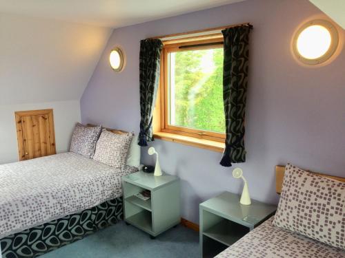 a bedroom with two beds and a window at The Lovecroft Guest House in Laide