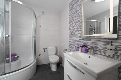 Un baño con inodoro, lavabo y ducha. en Keko, en Supetar