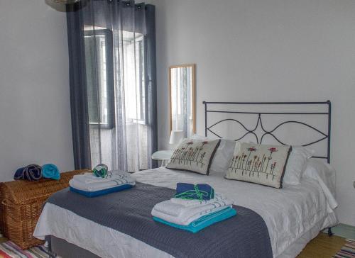 a bedroom with a large bed with towels on it at Casa da Igreja Velha in Furnas