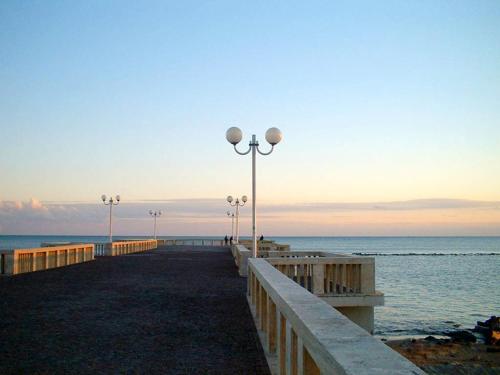 a pier with benches and lights on the beach at B&B Lido Liberty in Lido di Ostia