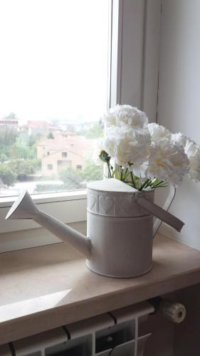 a bucket of flowers sitting on a window sill at Bonjour Bonheur in Avellino