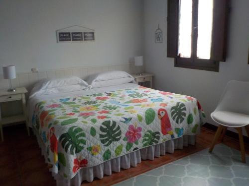 a bedroom with a bed with a colorful comforter at Posada Tresvalle in Ubiarco