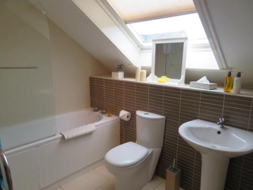 uma casa de banho com um WC branco e um lavatório. em Orasaidh Apartment em Stornoway