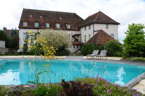 a house with a swimming pool in front of a building at Hostellerie de la Tour d'Auxois in Saulieu