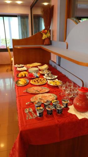 un tavolo rosso con piatti di cibo sopra di Hotel Natalia a Bellaria-Igea Marina