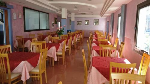 una fila di tavoli e sedie in un ristorante di Hotel Natalia a Bellaria-Igea Marina
