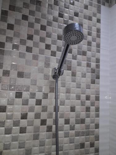 a shower with a shower head in a bathroom at Golden Queen Suites in Baguio