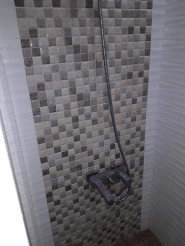 a shower with a gray and white tiled wall at Golden Queen Suites in Baguio