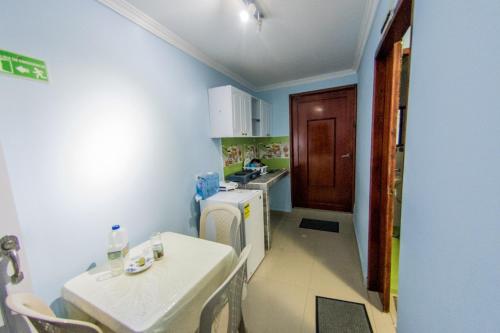 a small kitchen with a table and a refrigerator at Apartamentos Katy in San Andrés