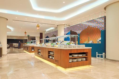 a restaurant with a counter in the middle of a room at Holiday Suites Al Azizia in Makkah