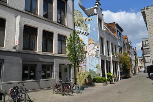 un groupe de vélos garés dans une rue abritant des bâtiments dans l'établissement Huize Amoras, à Anvers