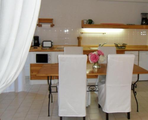 グレウー・レ・バンにあるLocations Thermaë - Villa Thermaëのキッチン(木製テーブル、白い椅子付)