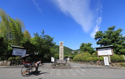 a man standing next to a bike on a street at 一棟貸切り宿 GuestHouse 嵯峨嵐山 in Kyoto
