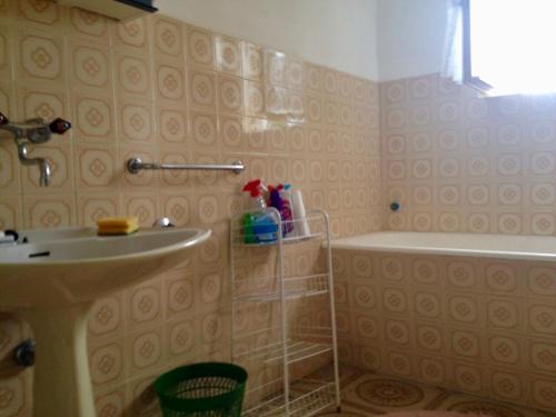 La salle de bains est pourvue d'un lavabo et d'une baignoire. dans l'établissement Guest house Brodarica, à Brodarica