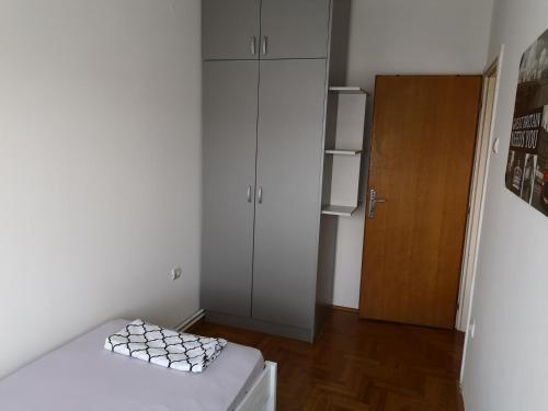 a small white room with a refrigerator and a table at Plaža in Sremska Mitrovica