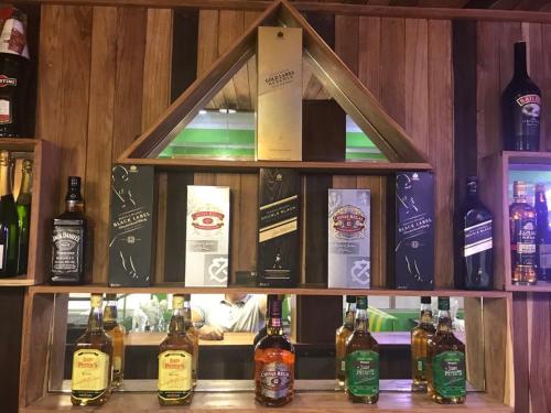 une exposition de bouteilles d’alcool sur une étagère dans l'établissement New Park Resort, à Mahajanga