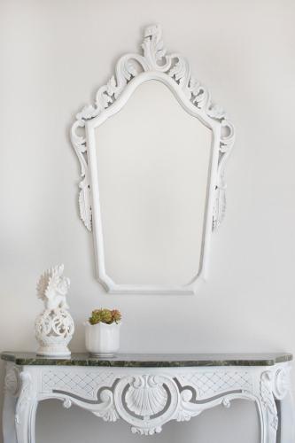 a mirror on a white wall above a table at Fiora Villas in Trapezaki